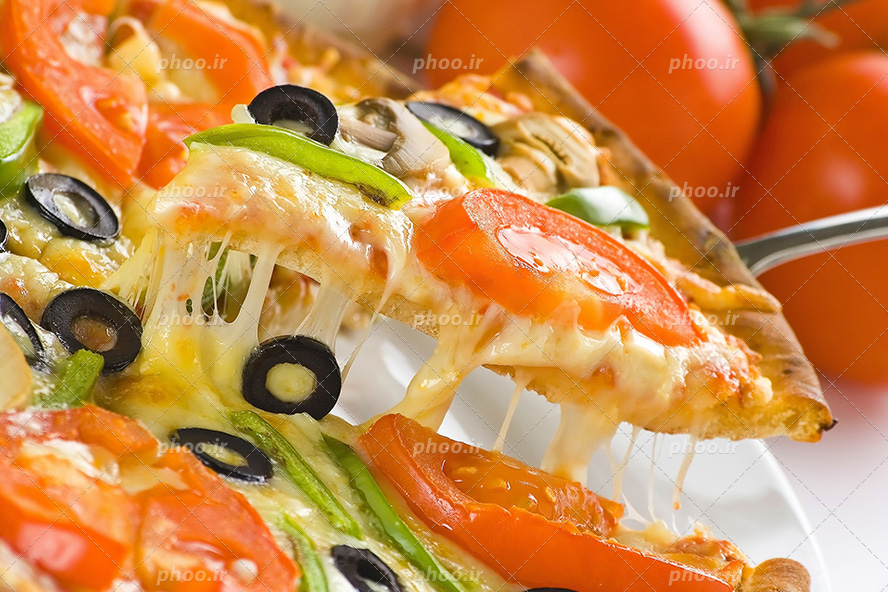 عکس با کیفیت برداشتن یک اسلایس پیتزا سبزیجات از نمای نزدیک