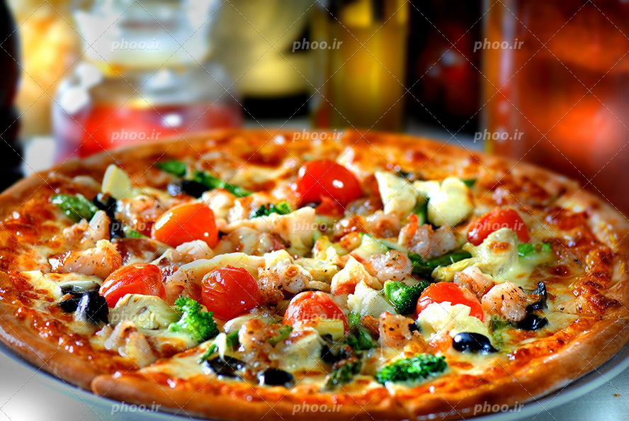 عکس با کیفیت پیتزا خوشمزه سبزیجات با تزئین گوجه و زیتون سیاه و کلم بروکلی