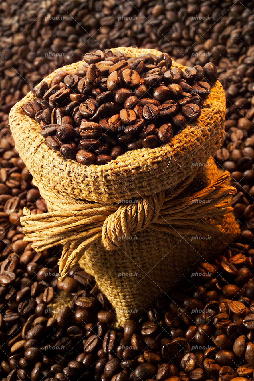 عکس با کیفیت دانه های تازه قهوه در گونی کنفی و گونی غرق در دانه های قهوه