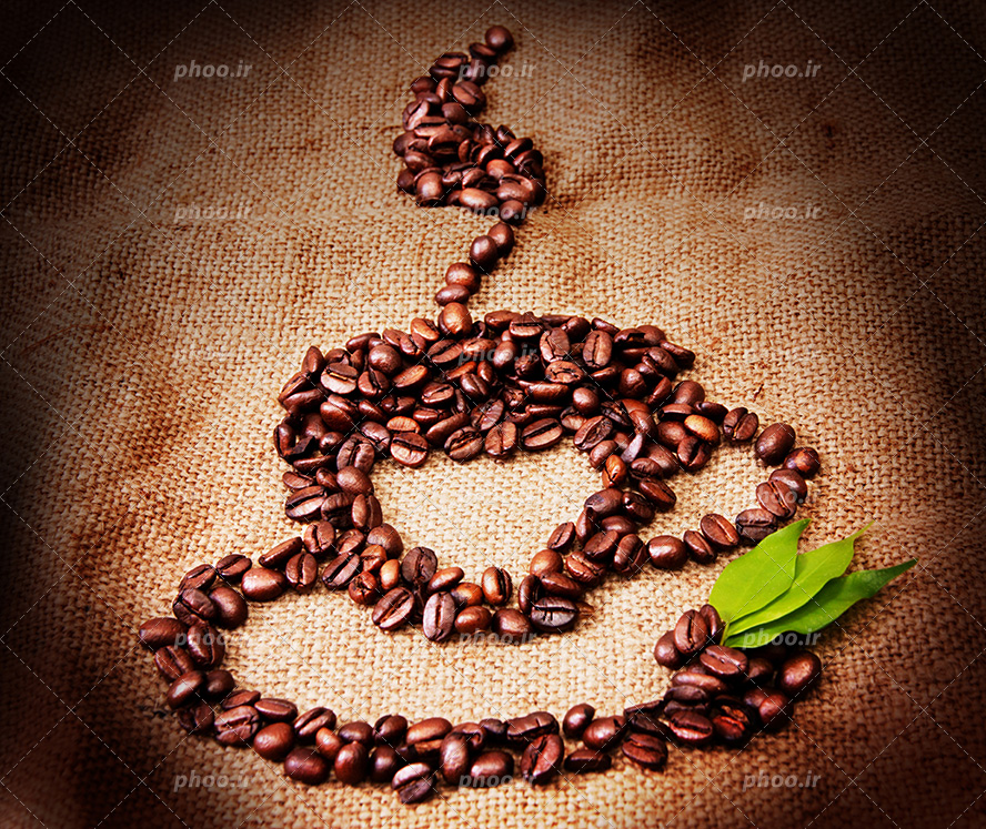 عکس با کیفیت دانه های قهوه به شکل فنجان بر روی گونی کنفی و سه برگ سبز در کنار فنجان