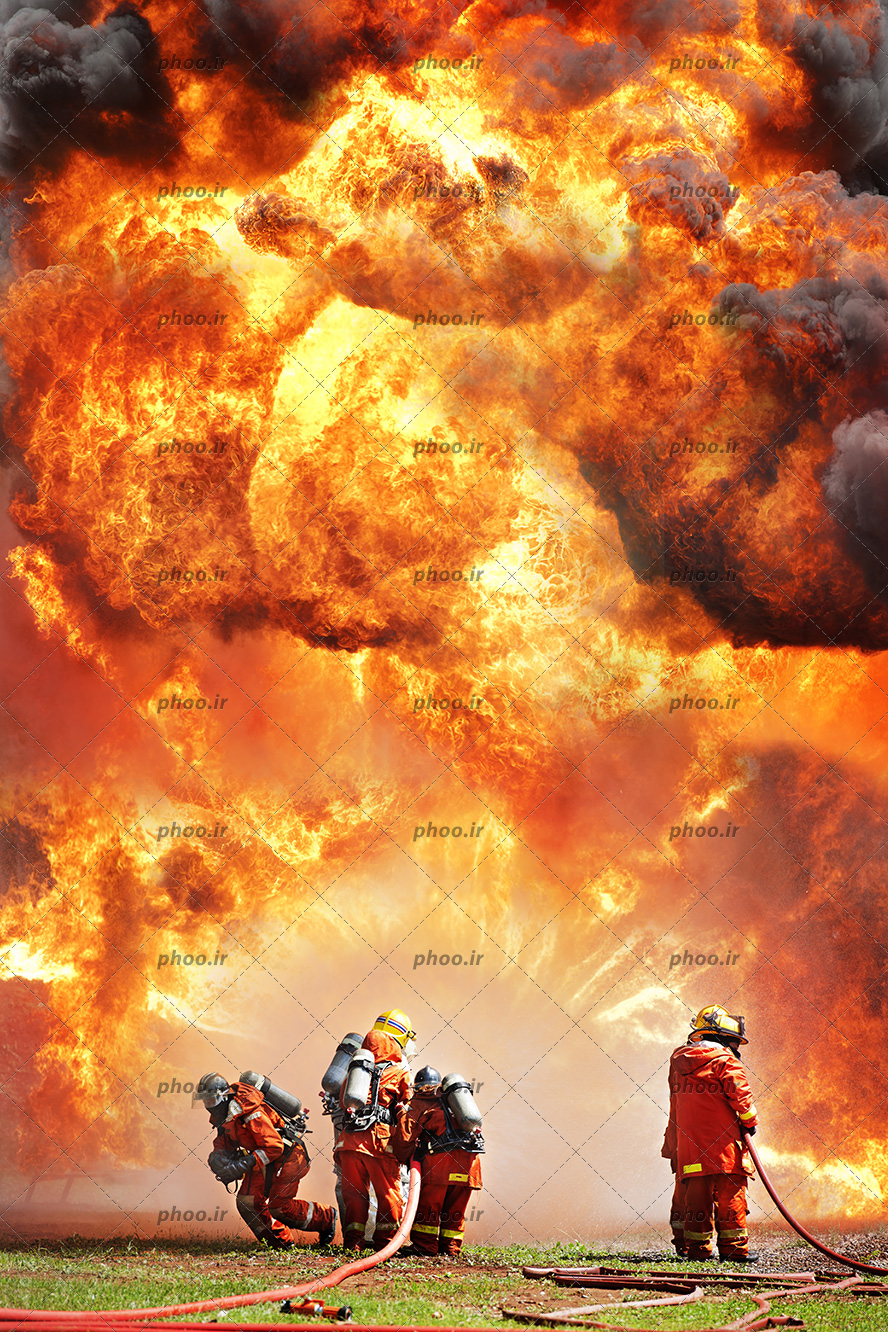 عکس با کیفیت چهار آتش نشان در حال خاموش کردن شعله های آتش با شلنگ های آب ماشین آتش نشانی