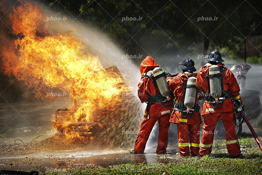 عکس با کیفیت آتش نشان ها در حال خاموش کردن ماشین غرق در آتش