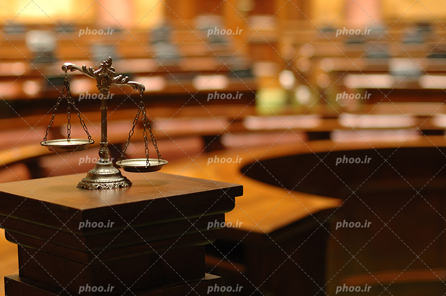 عکس با کیفیت ترازو عدالت بر روی میز چوبی در دادگاه بزرگ
