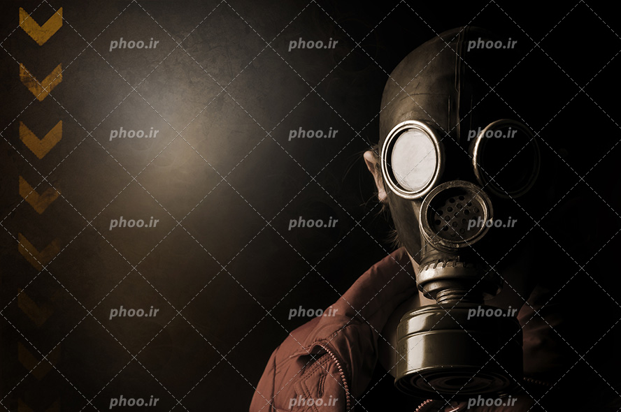عکس با کیفیت ماسک ضد شیمیایی بر روی صورت مرد و لباس زرشکی بر تن و دیوار پشت سر مرد به رنگ مشکی و فلش های زرد بر روی دیوار