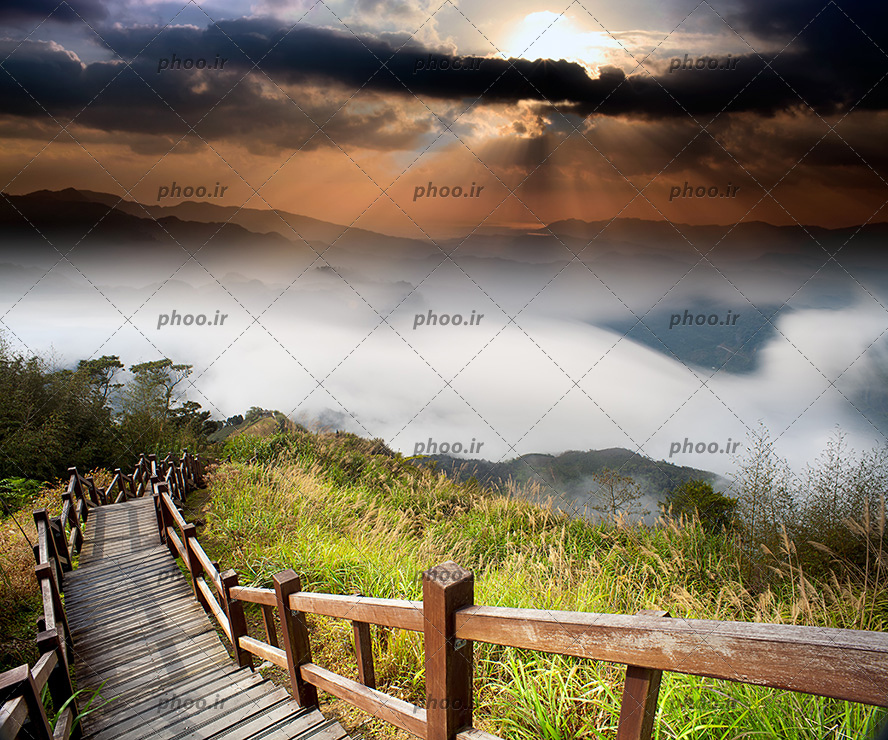 عکس با کیفیت پلکان منتهی به دره ی مه گرفته و آسمان در حال غروب