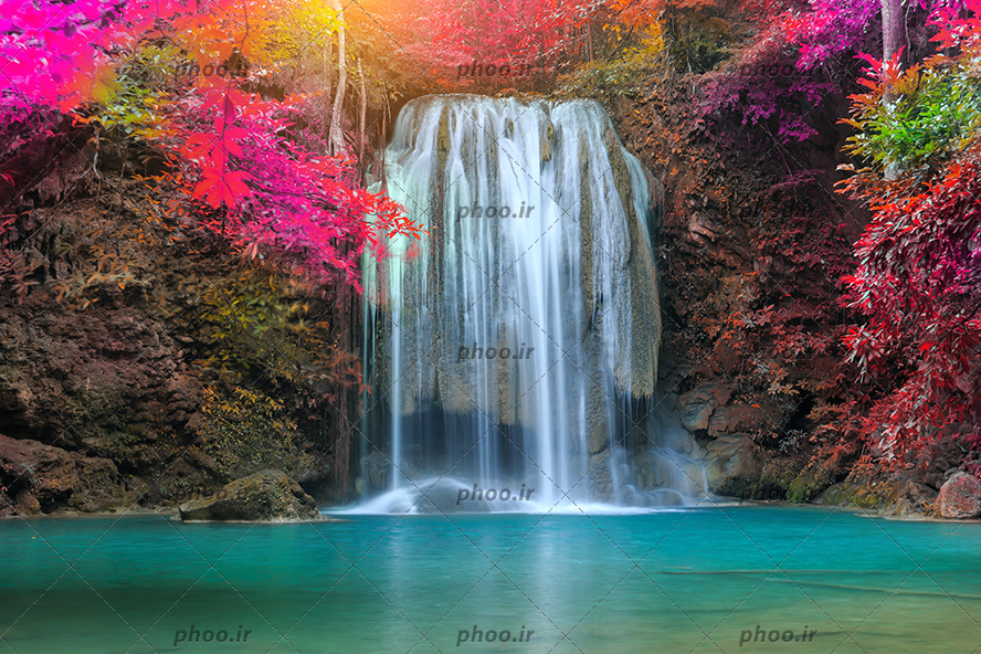 عکس با کیفیت آبشار و دریاچه با آب زلال و درختان به رنگ صورتی در اطراف آبشار