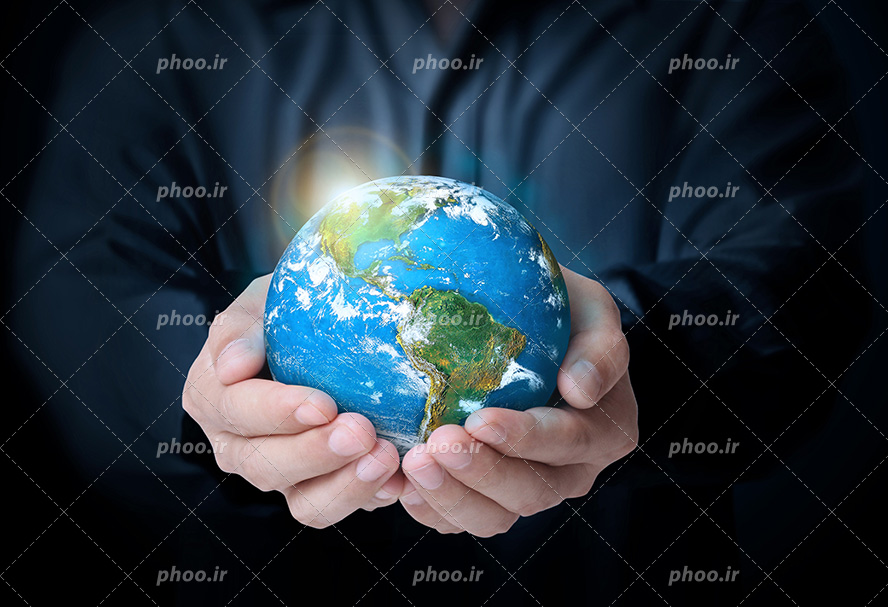 عکس با کیفیت کره ی زمین در دستان مرد و درخشش نور در قسمتی از کره زمین
