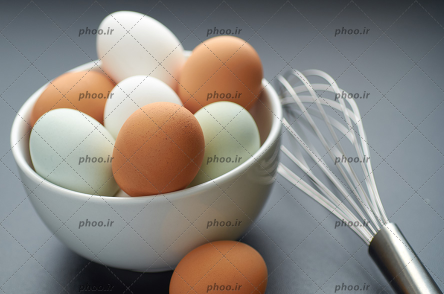 عکس با کیفیت تخم مرغ خانگی و تخم مرغ ماشینی داخل ظرف و همزن دستی در کنارش