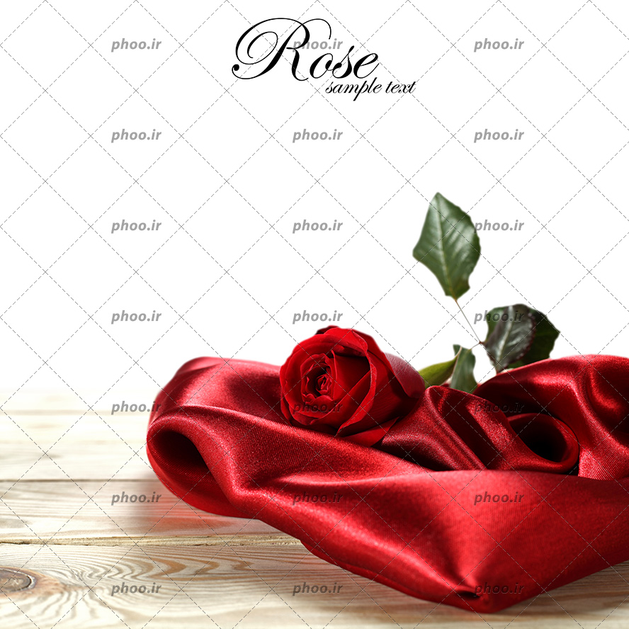 عکس با کیفیت یک شاخه گل رز قرمز بر روی پارچه ی قرمز براق و قرار گرفته بر روی میز چوبی