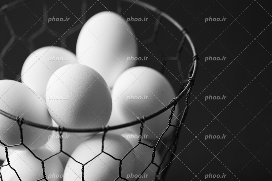 عکس با کیفیت تخم مرغ ها داخل سبد فلزی با طرح لانه زنبوری