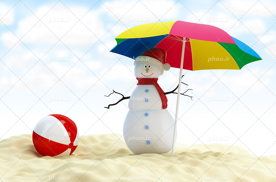 عکس با کیفیت چتر در دست آدم برفی با کلاه بابانوئل ایستاده بر روی ماسه های دریا و توپ قرمز در کنارش
