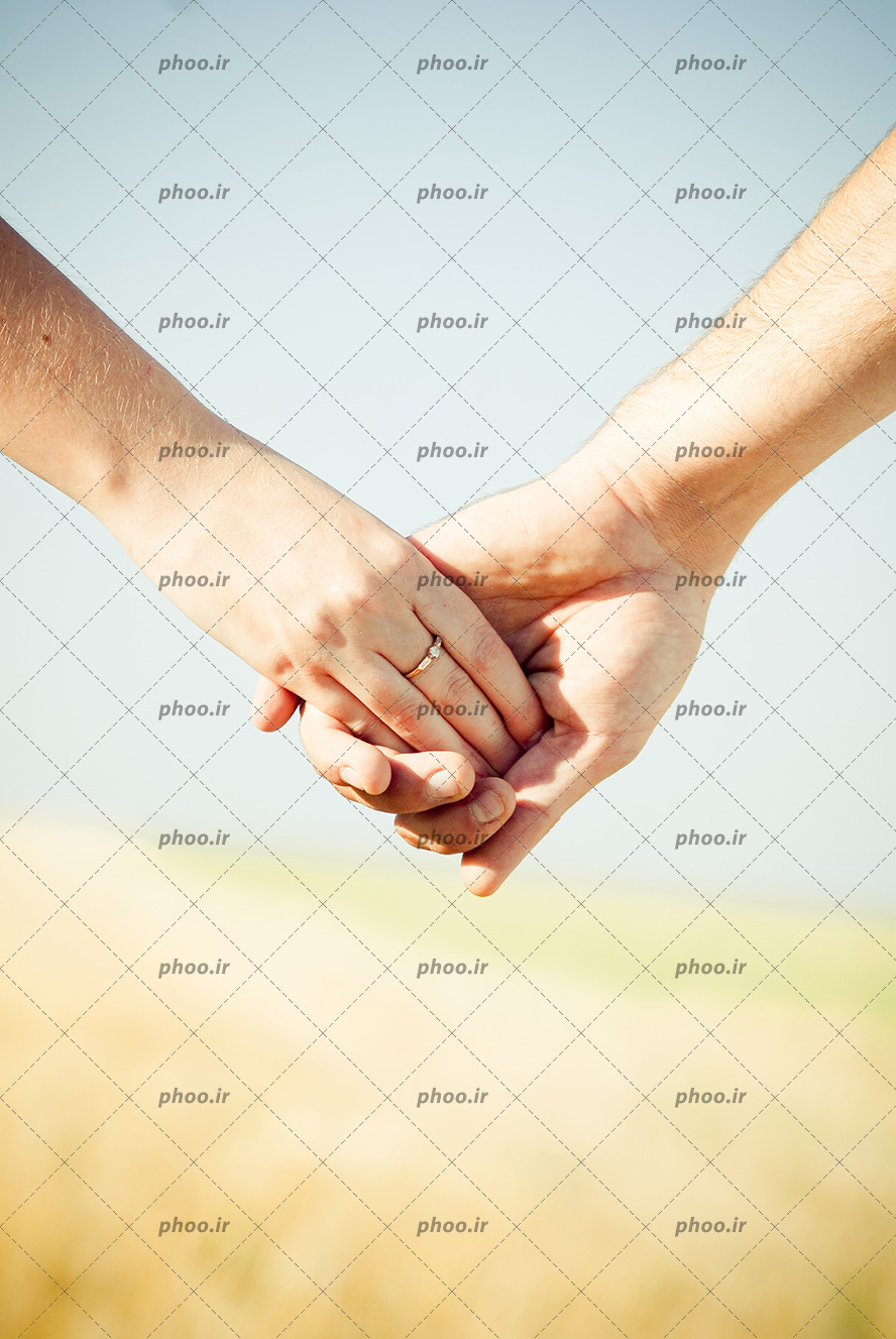عکس با کیفیت حلقه ازدواج در دست زن و زن و مرد دست در دست یکدیگر