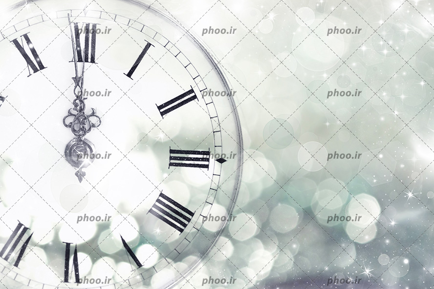 عکس با کیفیت ساعت با بدنه ی شیشه ای با اعداد یونانی در پس زمینه نورانی