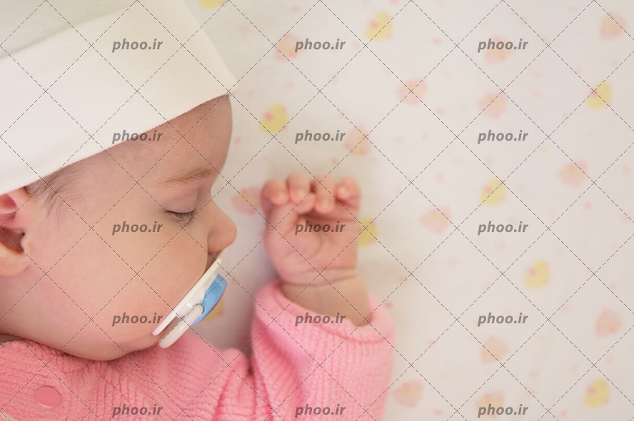 عکس با کیفیت چهره ی نوزاد خواب در حالت نیم رخ و در حال خوردن پستونک