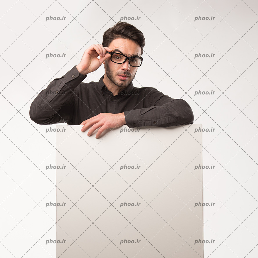 عکس با کیفیت مرد با پیراهن مشکی و در حال برداشتن عینک خود و کاغذ بزرگ در دست