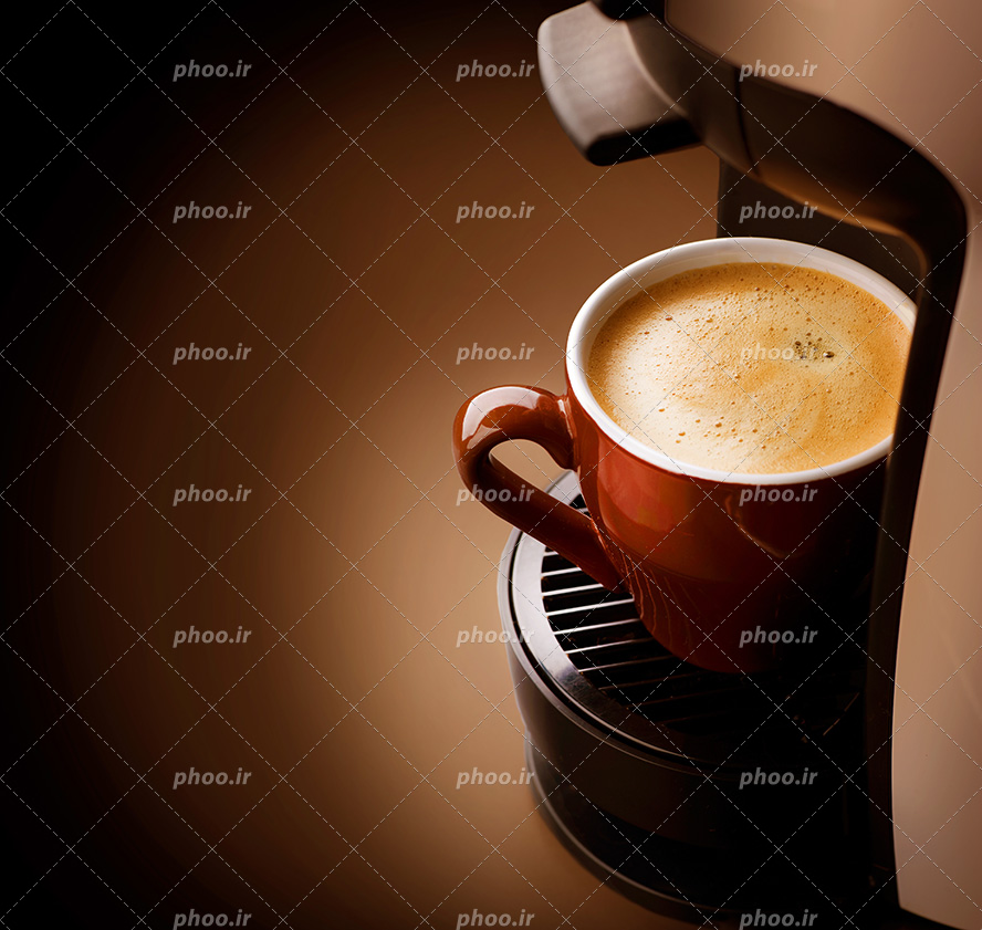 عکس با کیفیت ماگ سرامیکی نارنجی کاپوچینو بر روی قهوه ساز