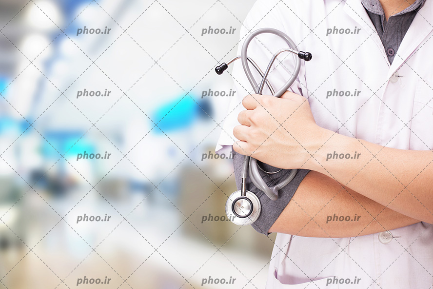 عکس با کیفیت پزشک ایستاده و دست به سینه و استتوسکوپ پزشکی در دستان او