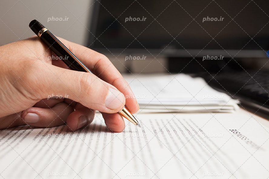 عکس با کیفیت خودنویس در دست مرد و در حال یاداشت در کتاب از نمای نزدیک