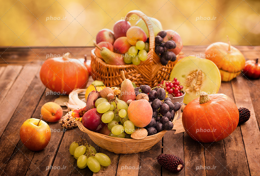 عکس با کیفیت دو سبد میوه پر شده از میوه های سالم و مقوی در کنار کدو های نارنجی