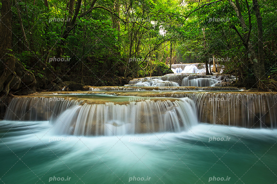 عکس با کیفیت آبشار کوچک در وسط جنگل سرسبز زیبا