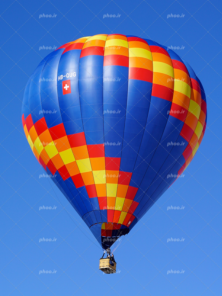 عکس با کیفیت بالن به رنگ آبی و زرد و قرمز در حال پرواز در آسمان آبی