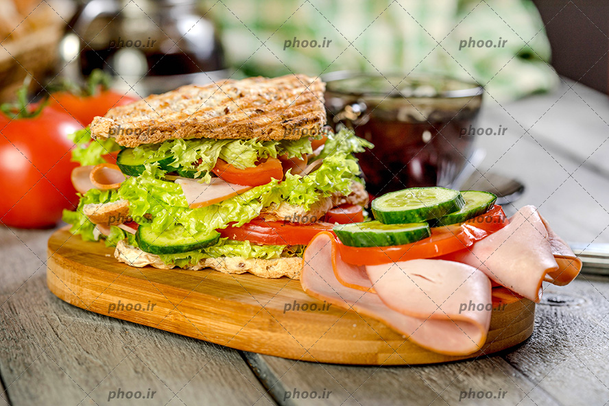 عکس با کیفیت ساندویچ کالباس به همراه مخلفات قرار گرفته بر روی تخته چوبی