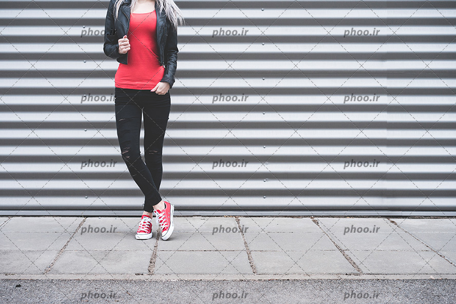 زن ایستاده در مقابل کرکره های مغازه با استایل اسپرت شیک