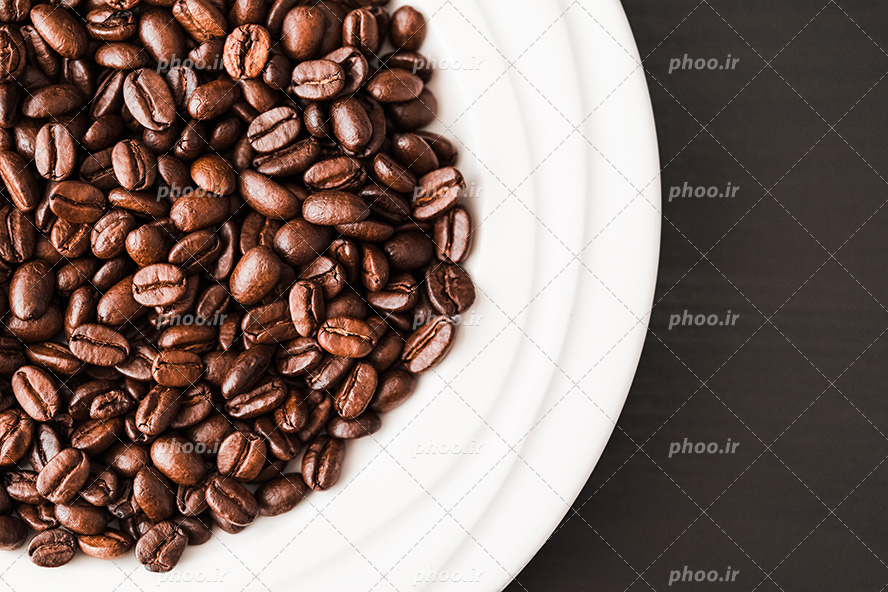 عکس با کیفیت دانه های کوچک قهوه در ظرف سفید در پس زمینه سفید