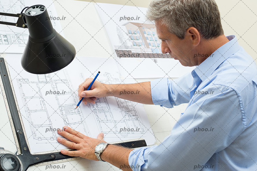 عکس با کیفیت مرد مهندس در حال نقشه کشی در اتاق کار