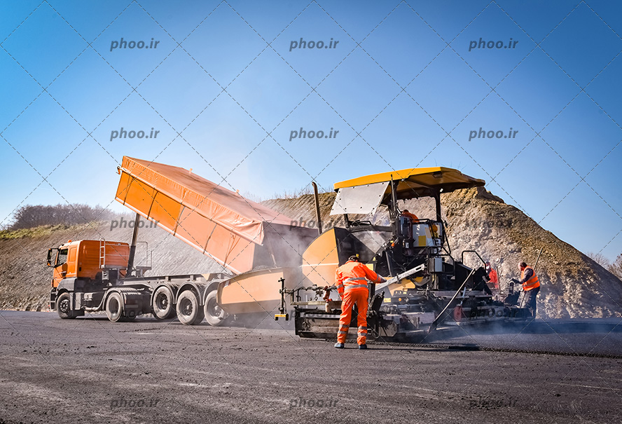 عکس با کیفیت کارگران در حال کار کردن در کنار جرثقیل و کامیون