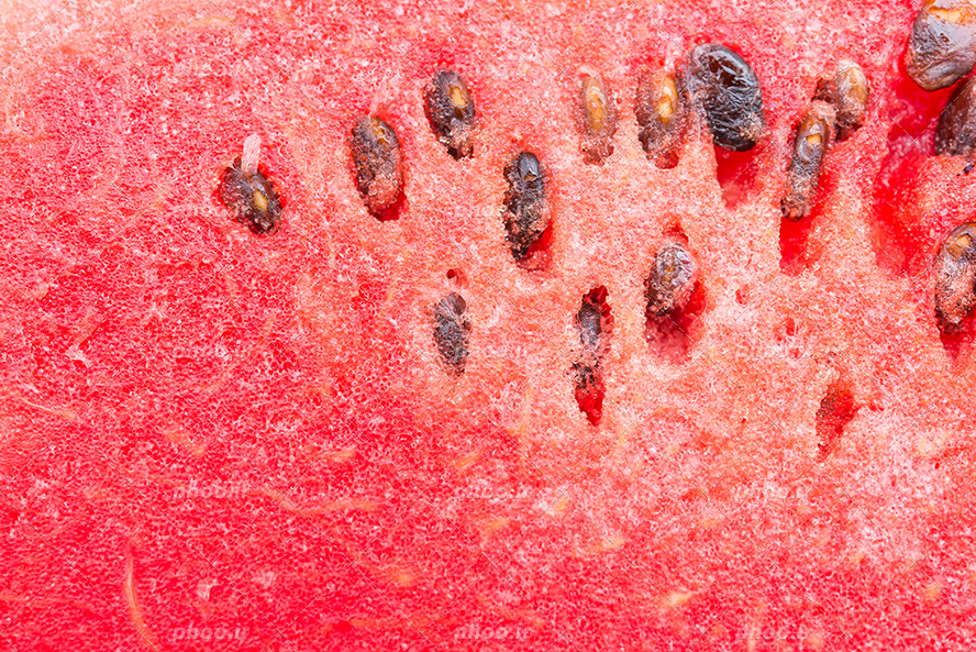 عکس با کیفیت نمای نزدیک از هندوانه و تخمه های سیاه بر روی آن