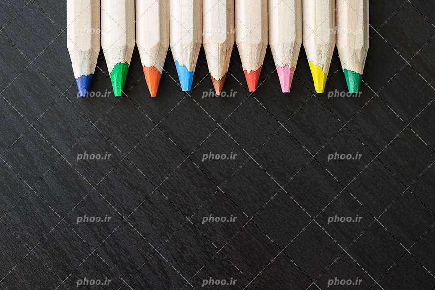 عکس با کیفیت مداد رنگی های رنگارنگ با بدنه ی کرمی رنگ در پس زمینه مشکی