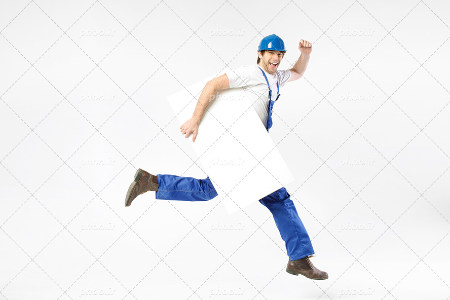 عکس با کیفیت مرد مهندس ساختمان با لباس آبی و کلاه ایمنی آبی رنگ و مقوای سفید در دست در حال دویدن با چهره ی خوشحال