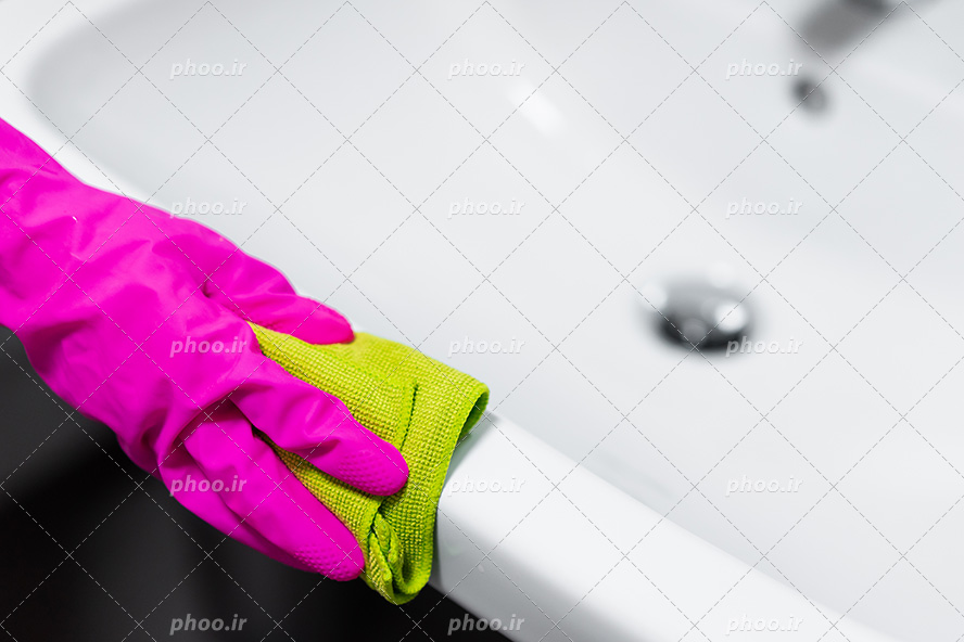 عکس با کیفیت زن کارگر در حال شستن و نظافت روشویی و سرویس بهداشتی
