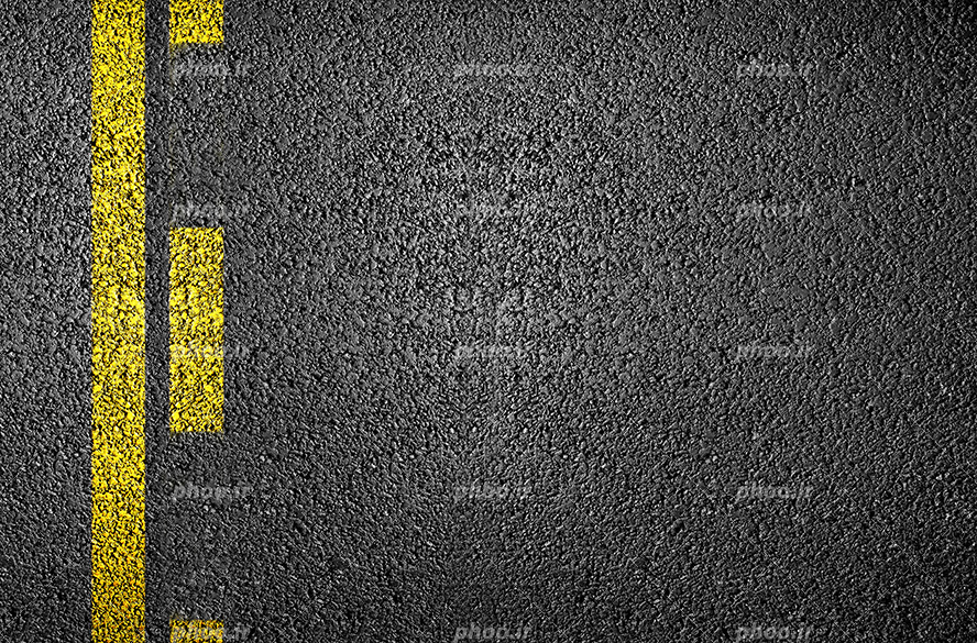 عکس با کیفیت زمین آسفالت شده با خط زرد و پاره خط های زرد رنگ به صورت موازی در کنار یکدیگر