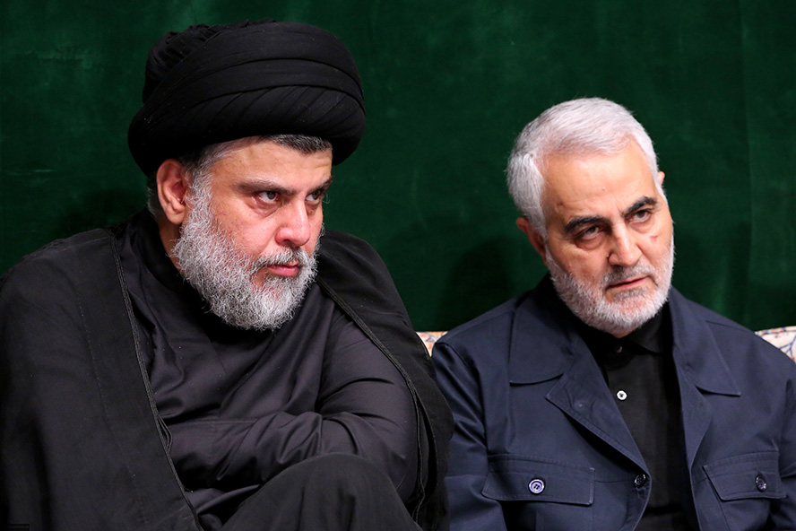 عکس با کیفیت تصویر شهید سردار قاسم سلیمانی نشسته و تکیه داده به پشتی در کنار مقتدی صدر