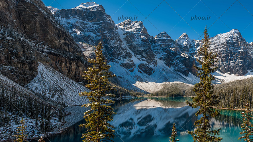 عکس با کیفیت طبیعت زیبا با کوه های مرتفع برفی با درختان کاج و دریاچه زیبا