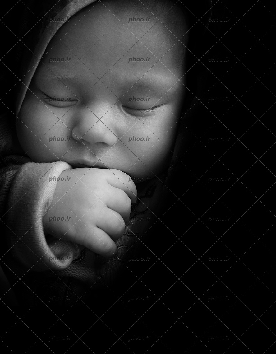 عکس یک نوزاد خوابیده در پس زمینه مشکی