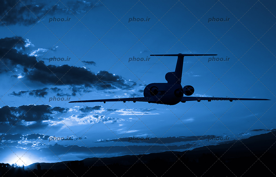 عکس یک هواپیما در حال پرواز در شبی تاریک و آسمان نیمه ابری