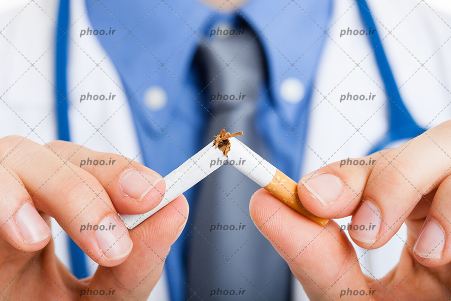 عکس با کیفیت پزشک با روپوش سفیدو پیرهن آبی در حال شکستن یک نخ سیگار