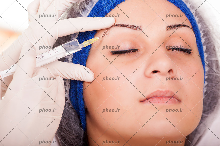 عکس با کیفیت دکتر در حال تزریق ژل با سرنگ به پوست صورت زن