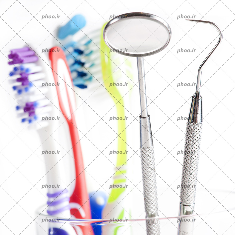 عکس با کیفیت تجهیزات دندان پزشکی در کنار چند مسواک رنگارنگ در بک گراند سفید