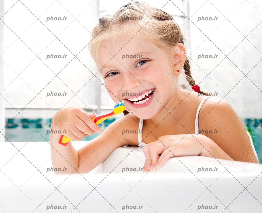 عکس با کیفیت دختر بچه با لبخند زیبا و موهای طلایی در حال مسواک زدن