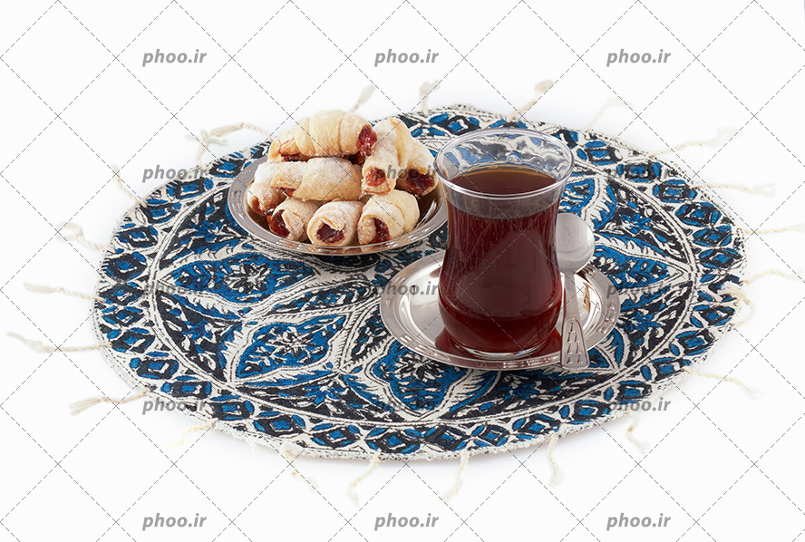 عکس با کیفیت شیرینی های کوچک داخل ظرف در کنار چای داخل استکان کمر باریک و داخل سینی زیبا با طرح های اسلیمی و سنتی