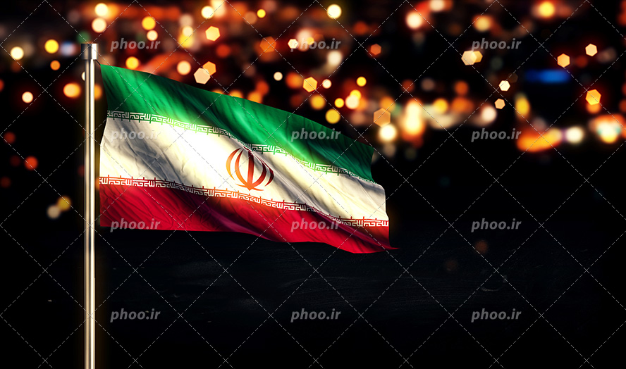 عکس با کیفیت پرچم ایران وصل به میله آهنی و پس زمینه شهر از نمای دور به شکل نور