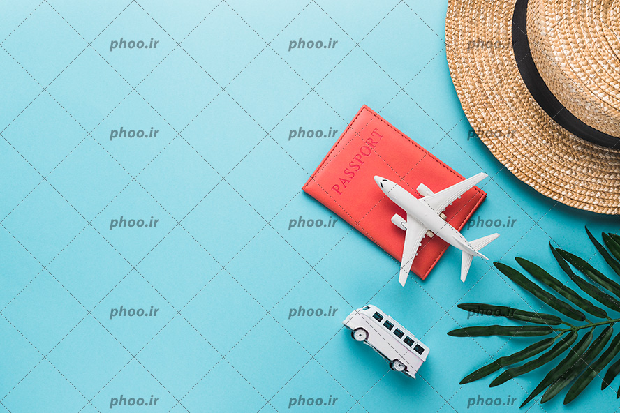 عکس با کیفیت ماکت هواپیما روی جلد چرمی پاسپورت و ون در کنار آن و کلاه حصیری و برگ سبز در گوشه ای از تصویر