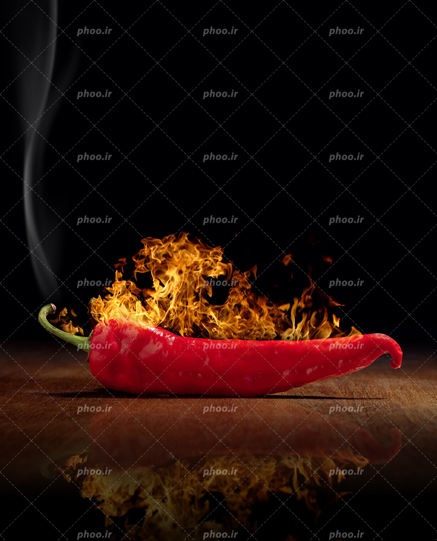 عکس با کیفیت فلفل قرمز تند در حال آتش گرفتن در بک گراند مشکی