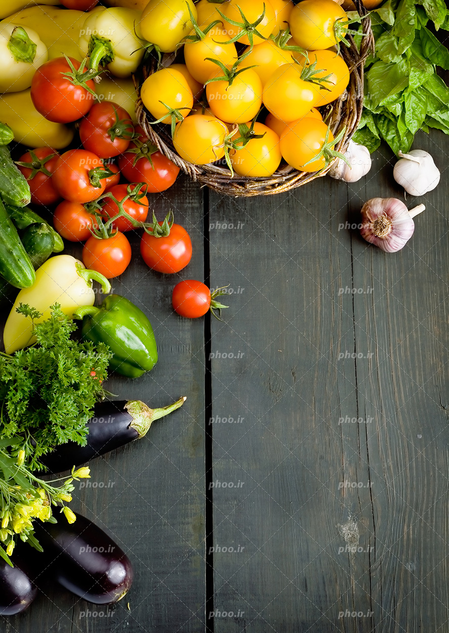 عکس با کیفیت انواع سبزیجات خوش رنگ و میوه جات چیده شده در کنار یکدیگر بر روی میز چوبی