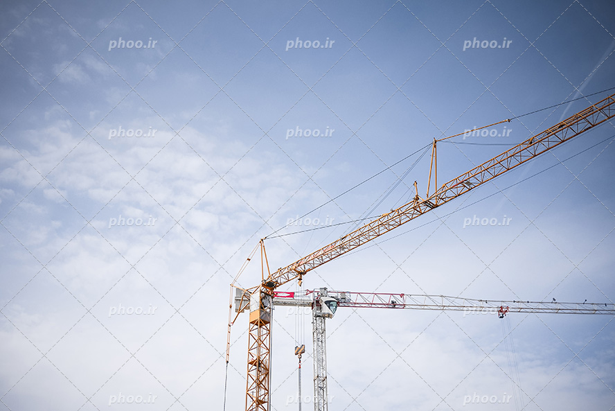 عکس با کیفیت تاورکرین زرد در آسمان آبی در حال کمک به ساخت و ساز ساختمان