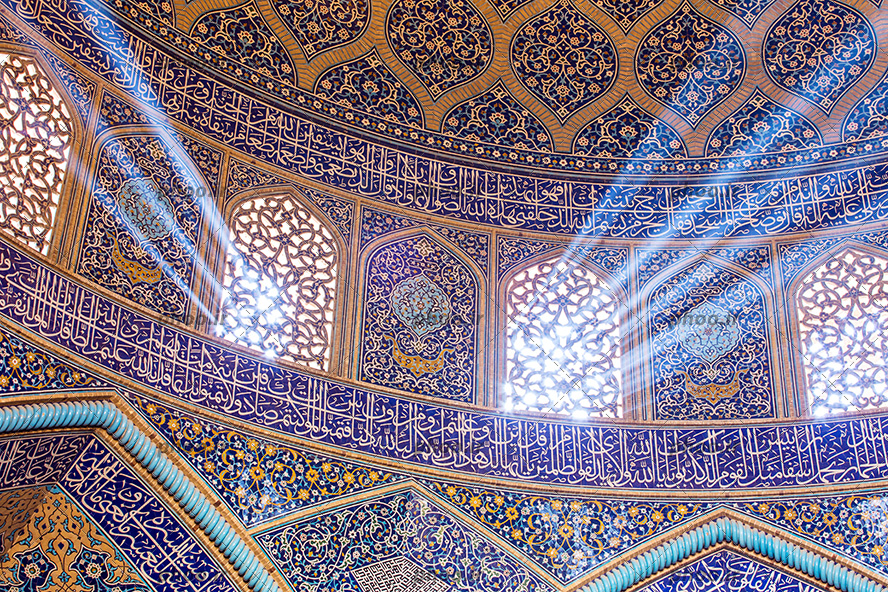 عکس نمای داخلی مسجد با گنبد کاشی کاری شده زیبا با آیات قرآن و پنجره های چوبی که از آن نور به زیبایی در جهت های مختلف به داخل تابیده شده